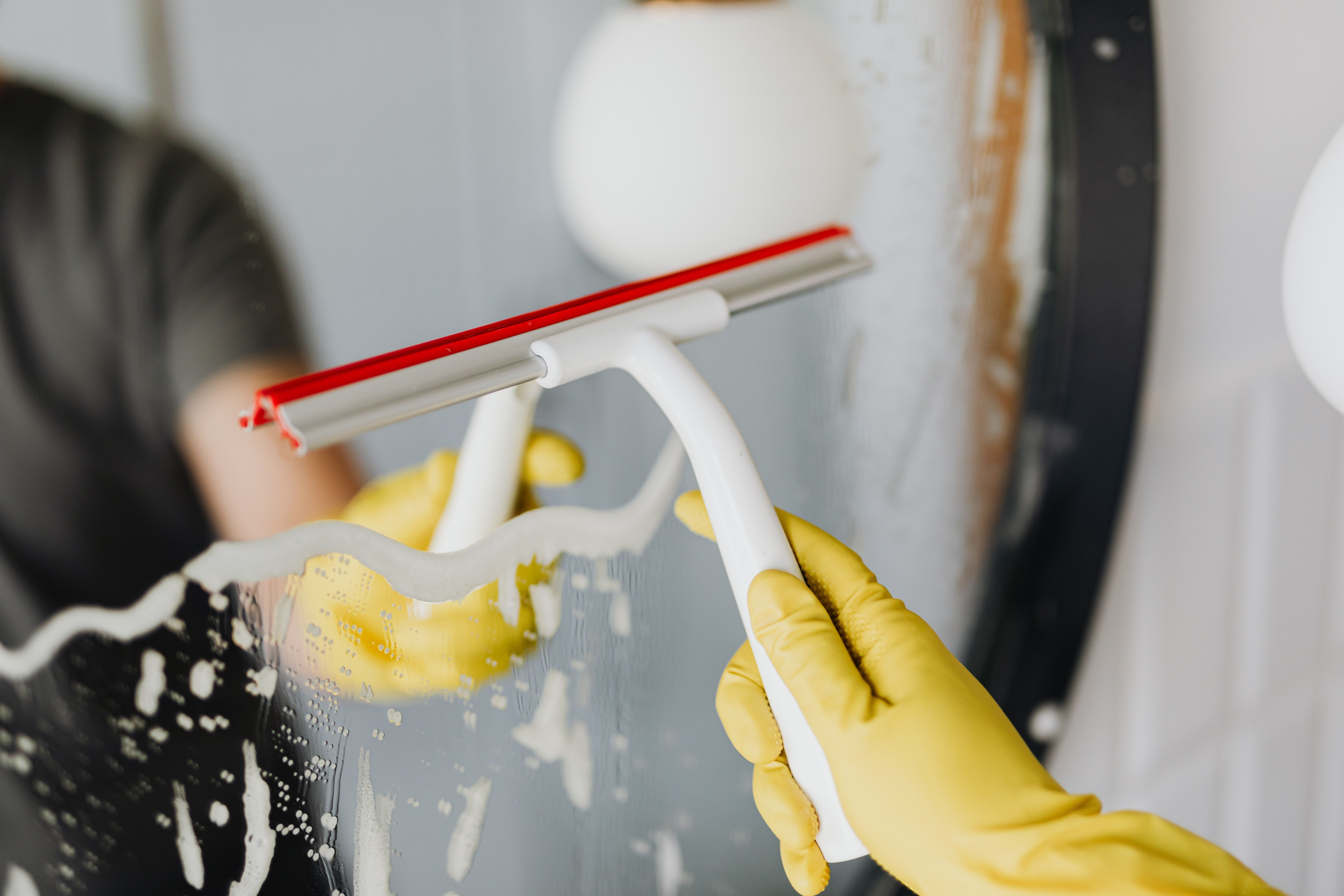 An Seilen hängende Fensterputzer reinigen die Glasfassade eines Hochhauses.